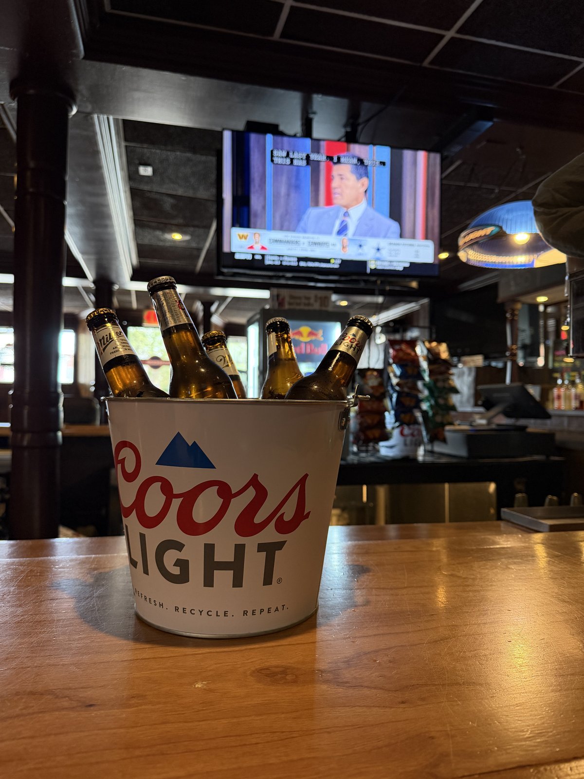 A beer bucket on the bar during football season