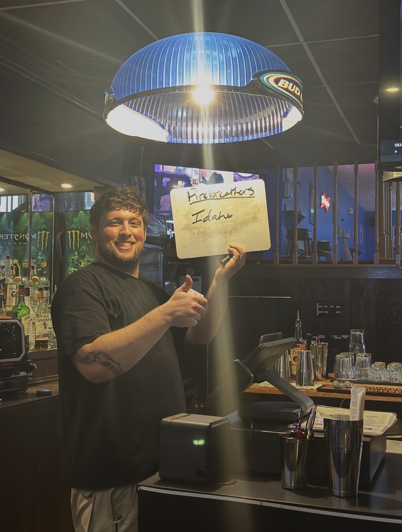 Bartender holding the specials board behind the bar